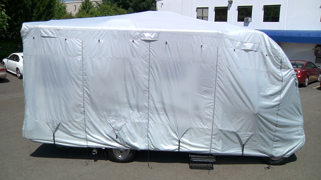 An RV is shown with an RV cover in place.