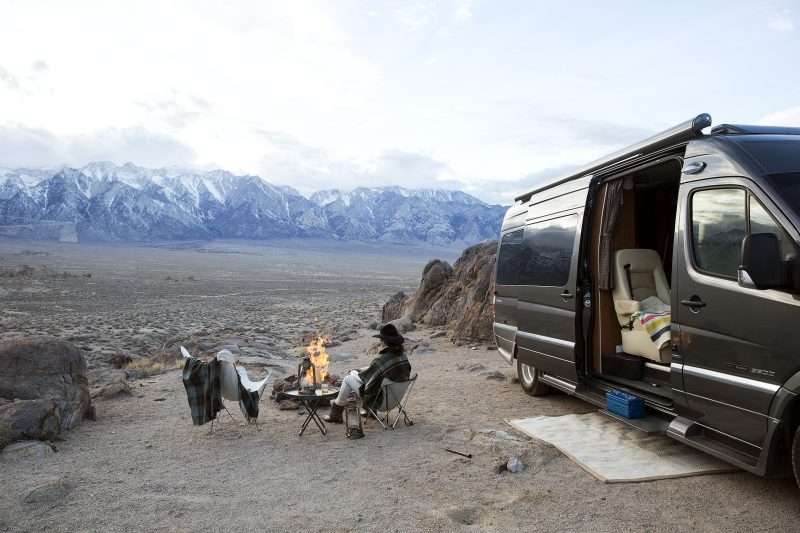 A Class B motorhome (B-Van) parked in the desert with mountains in the distance