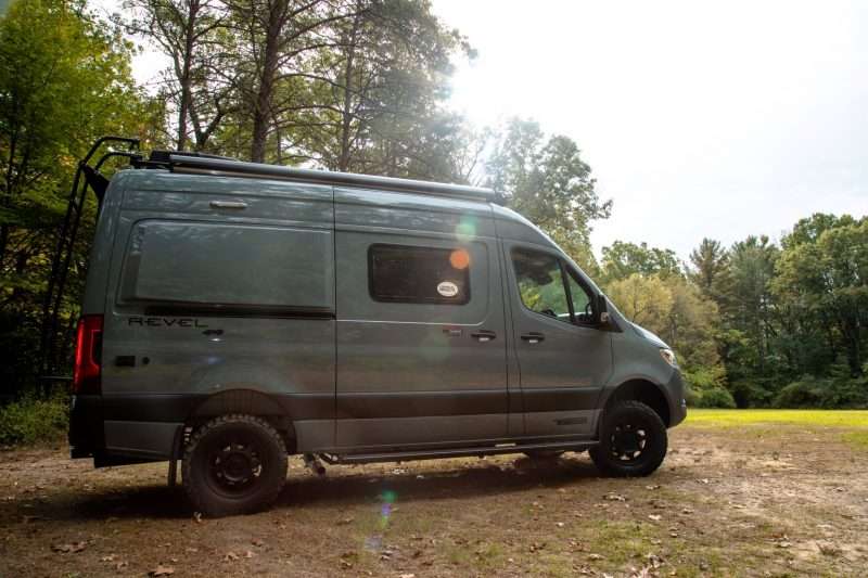 Winnebago Revel camper van in woods.