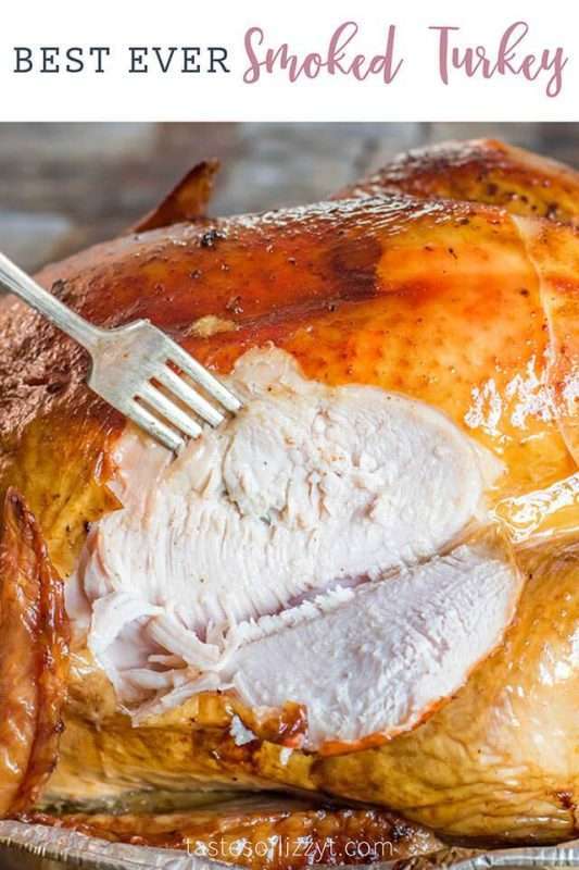 A closeup photo of a golden brown smoked turkey being carved. A fork is piercing the juicy white meat of this easy recipe for smoked turkey breast.