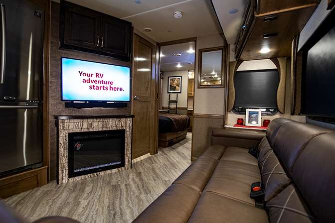 Inside the Fleetwood Bounder 35K, the leatherette couch provides a front row seat to the LED TV and built in fire place.