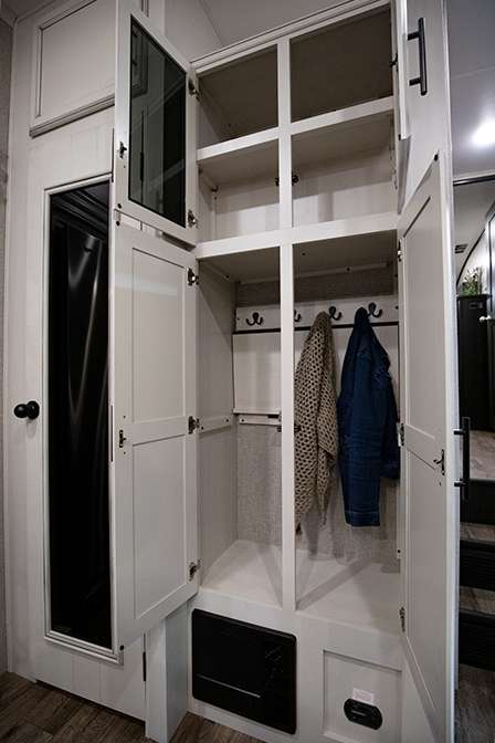 A photo of the Jayco Eagle 317RLOK's storage options. The large pantry is behind a door on the left and a tall storage closet with coat hooks is on the right. 