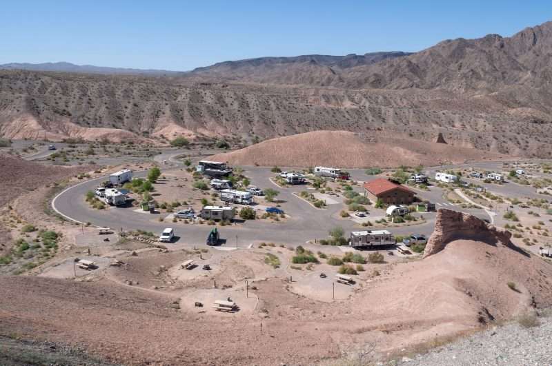 Multiple RVs and vehicles are parked at the Willow Beach RV Park and campground. The campground is situated in the heart of this striking landscape of mountains and valleys. 
