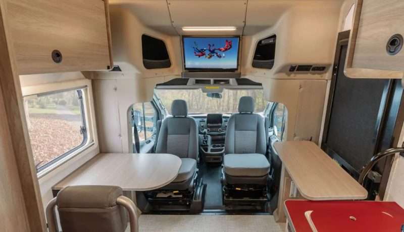 The interior of the Winnebago EKKO motorhome. The cab seats are swiveled around to face the galley and living area.