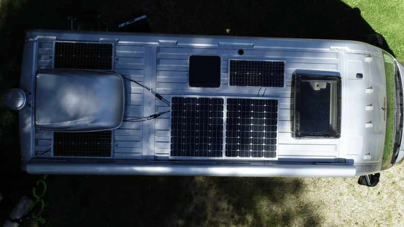 A photo from above shows the roof a Class B motorhome with five RV solar panels and one cargo container.