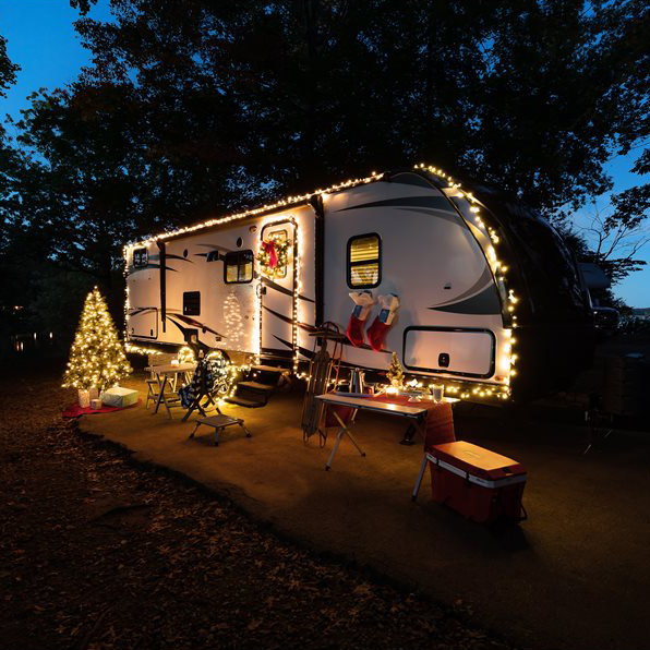 The outside of an RV is decorated for the holidays with the Currituck cooler sitting next to it.