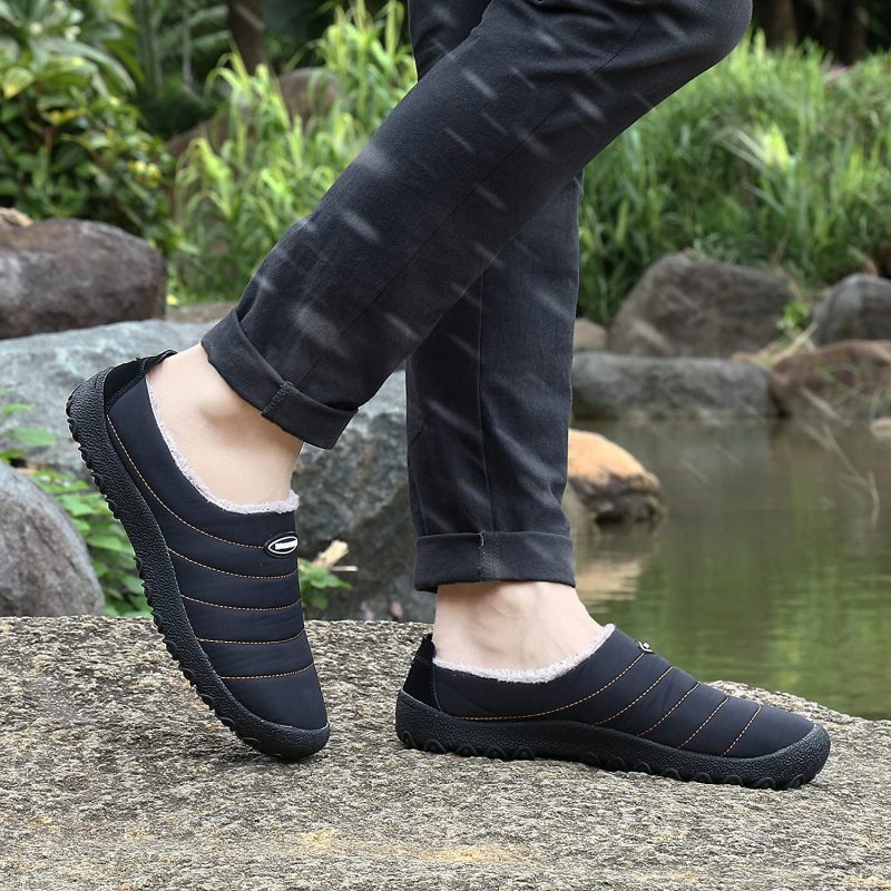 A woman walking next to a pond with the UBFEN slippers in black.