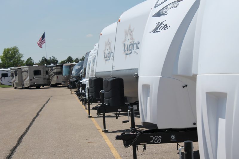 A line of different RVs on a parking lot.