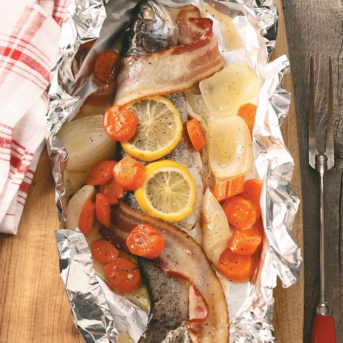 A Grilled Campfire Trout Dinner being prepped in a foil packet.