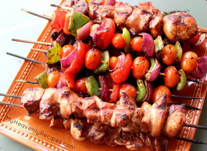 Cooked Steak and Chicken Kabobs and veggies on a plate.
