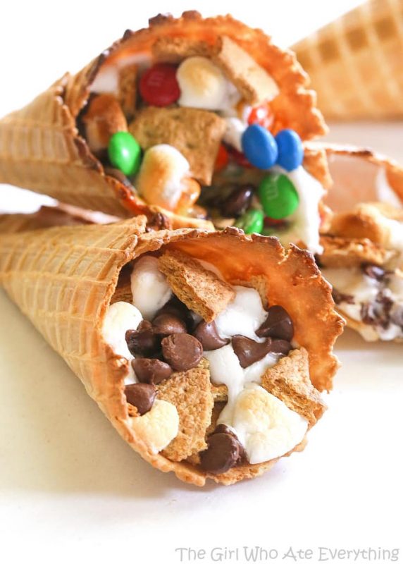 Three campfire cones with various toppings are laying on a table.