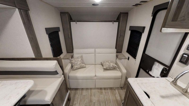 A convertible sofa inside the Coachmen Clipper Ultra-Lite. This new travel trailer RV is compact and lightweight.