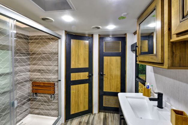 Master bathroom of the new Heartland Landmark Chesapeake fifth wheel RV features a large shower with teak seat