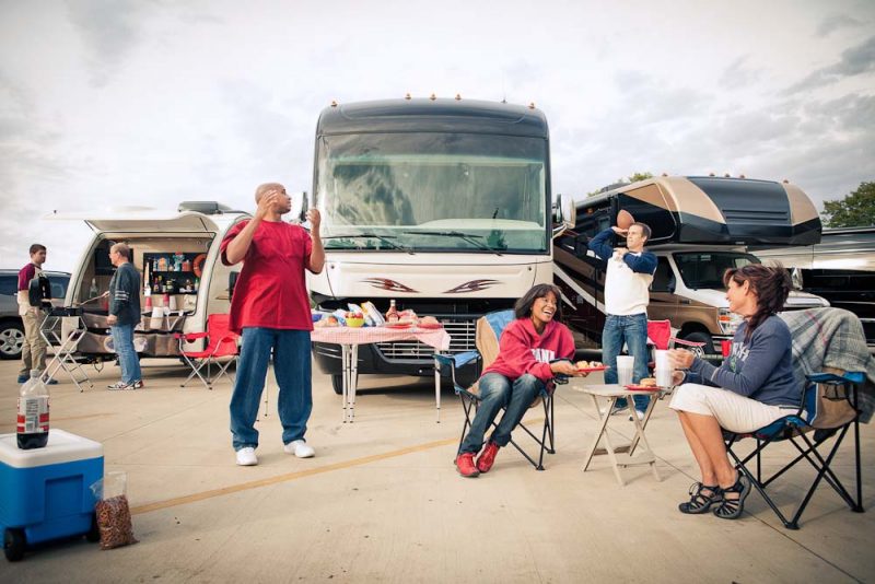 A group of friends are tailgating with their RVs.