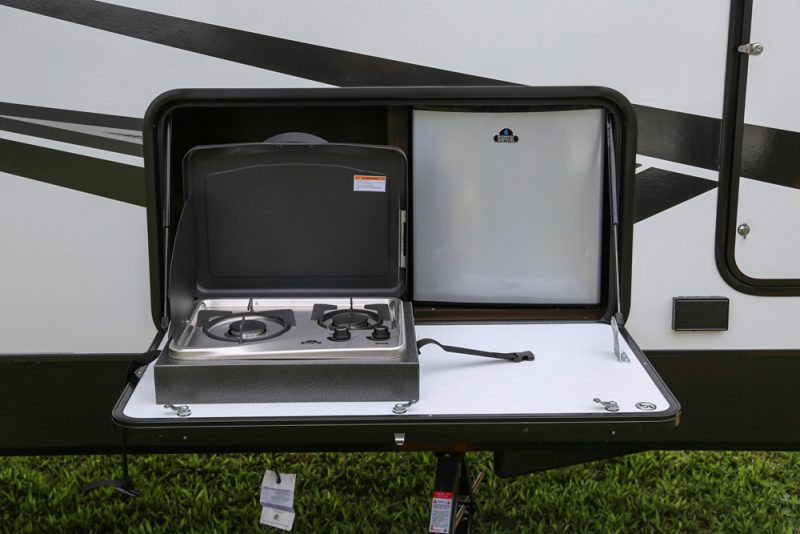 The outdoor kitchen with the two burner grill and mini fridge.