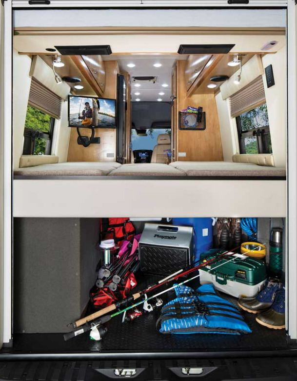 The interior of the Coachmen Galleria Class B RV has a bed with storage space below; this RV has fishing gear, a cooler, life jacket, camp chairs and more stored.