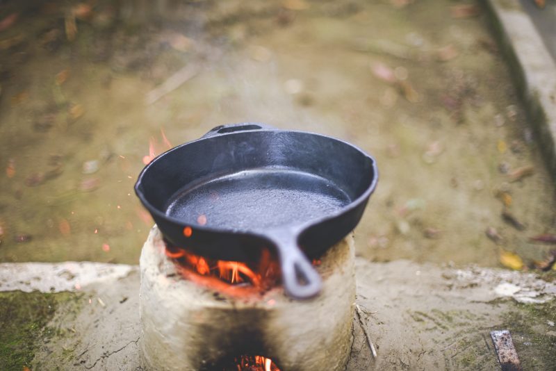Cast iron skillet heating over open flames
