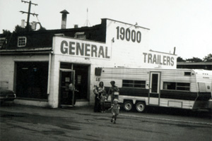 One of the first General Trailer stores with an RV and family in front of it.