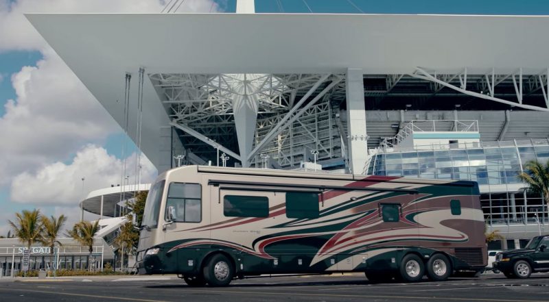 An RV pulling into a football stadium for game day.